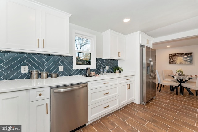 kitchen featuring stainless steel appliances, wood finish floors, white cabinets, and light countertops