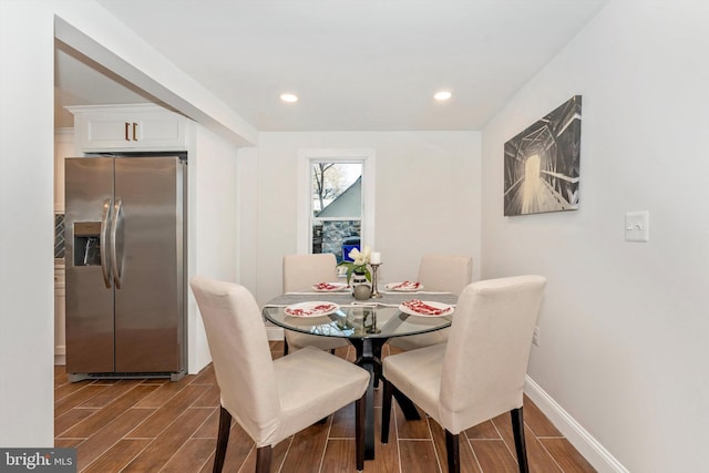 dining area featuring wood tiled floor, baseboards, and recessed lighting