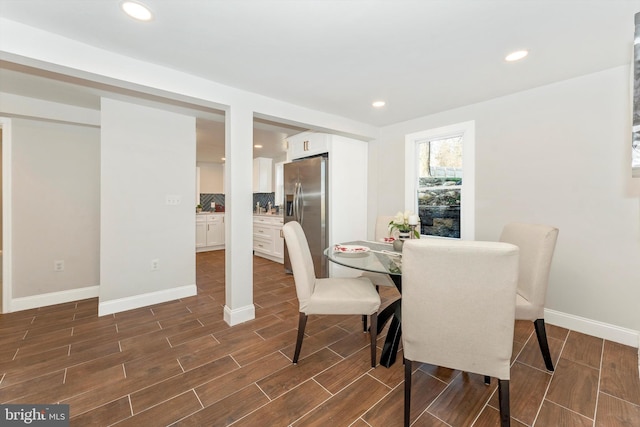 dining room featuring wood tiled floor, baseboards, and recessed lighting