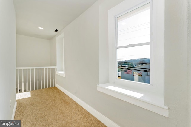 hall featuring carpet and baseboards