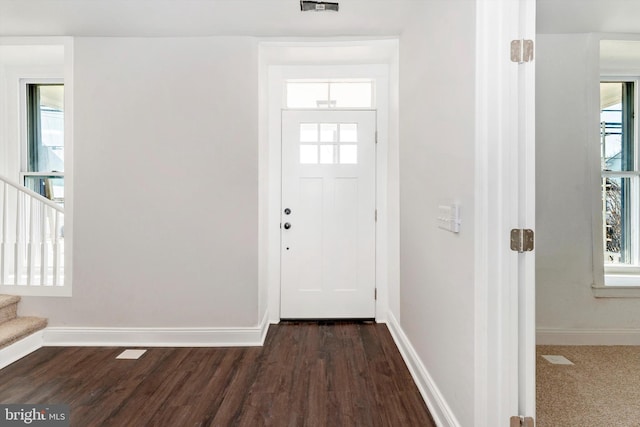 entryway featuring stairs, baseboards, and dark wood-type flooring