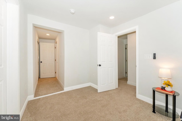 unfurnished bedroom with light carpet, recessed lighting, and baseboards