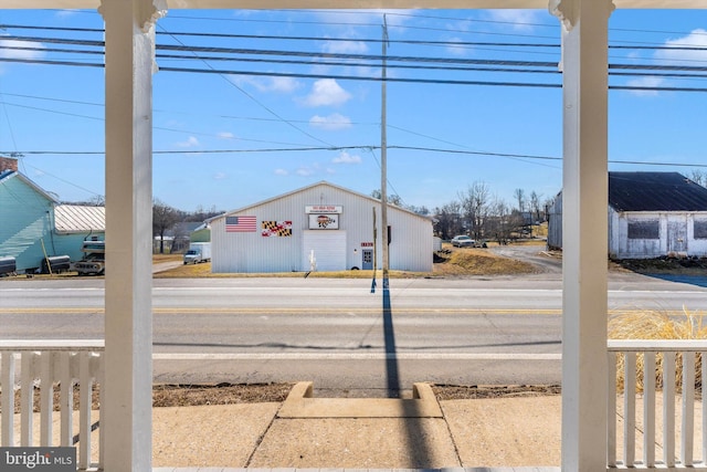 view of street featuring a pole building, curbs, and sidewalks