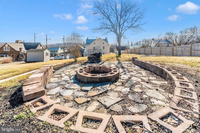 view of patio featuring a storage shed, an outdoor fire pit, an outdoor structure, and fence