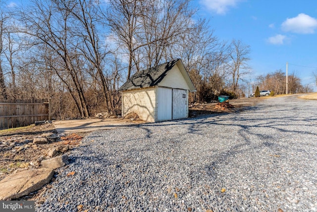 exterior space with fence and a storage shed