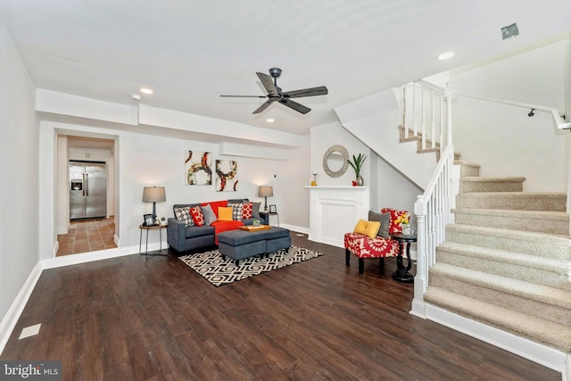 living area featuring stairs, dark wood-style flooring, and baseboards