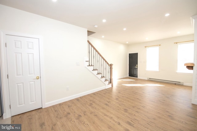 unfurnished room with baseboards, stairway, baseboard heating, light wood-type flooring, and recessed lighting