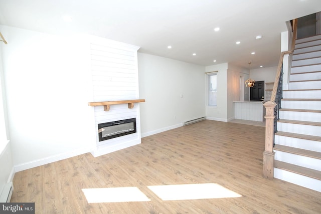 unfurnished living room with a glass covered fireplace, stairway, light wood-style floors, a baseboard heating unit, and recessed lighting