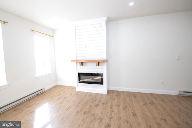 unfurnished living room featuring a large fireplace, light wood finished floors, baseboards, a baseboard radiator, and recessed lighting