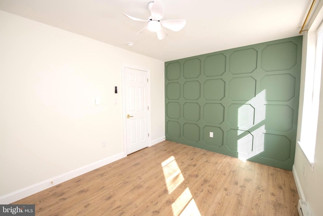 unfurnished bedroom with light wood-style floors, baseboards, a baseboard heating unit, and ceiling fan