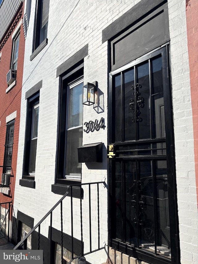 view of exterior entry featuring brick siding