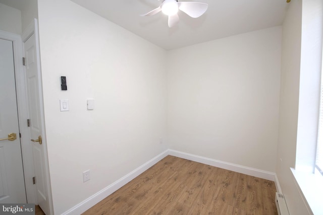 laundry area featuring light wood finished floors, baseboards, baseboard heating, and a ceiling fan