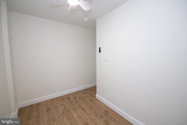 unfurnished room with a ceiling fan, light wood-style flooring, and baseboards