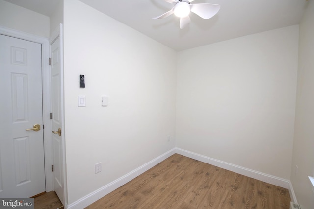 laundry area with ceiling fan, light wood finished floors, and baseboards