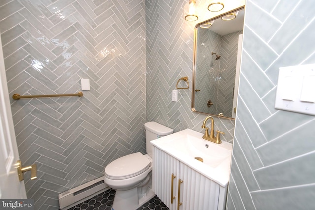 full bathroom with toilet, tile patterned floors, vanity, a baseboard heating unit, and tile walls