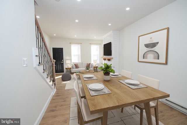 dining space featuring baseboards, a baseboard radiator, stairs, light wood-style floors, and recessed lighting