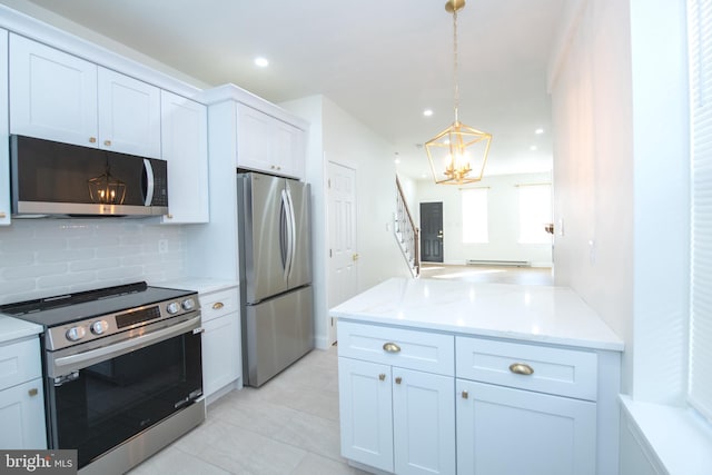 kitchen with tasteful backsplash, appliances with stainless steel finishes, light stone counters, hanging light fixtures, and white cabinetry