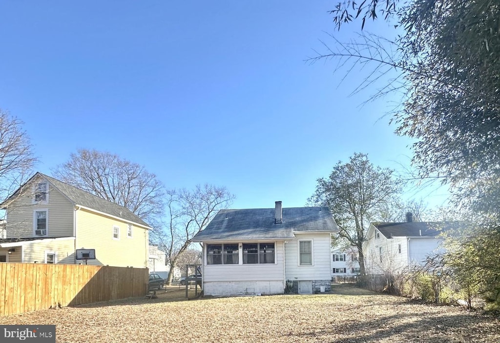 back of property with fence and a chimney