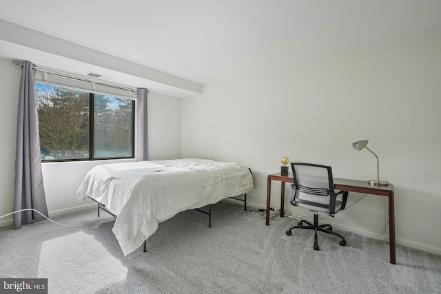 bedroom with baseboards and light colored carpet