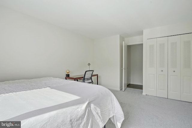 bedroom featuring light carpet, baseboards, and a closet