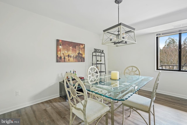 dining room with an inviting chandelier, baseboards, and wood finished floors