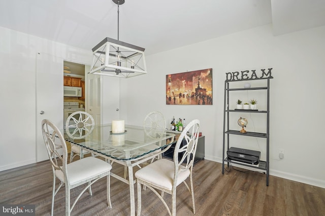 dining room featuring dark wood-style floors, a chandelier, and baseboards