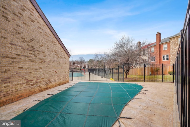 view of swimming pool featuring a patio area, fence, and a fenced in pool