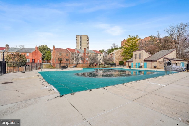 community pool with a residential view, fence, and a patio