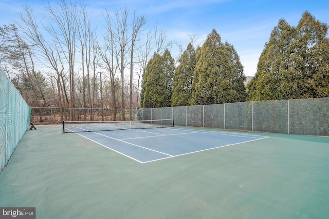 view of tennis court featuring fence