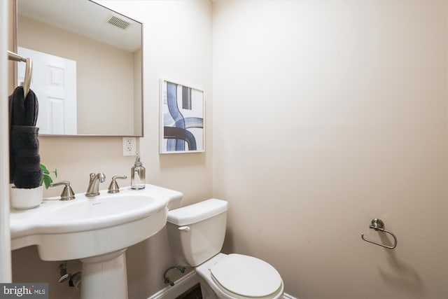 bathroom with visible vents, a sink, and toilet