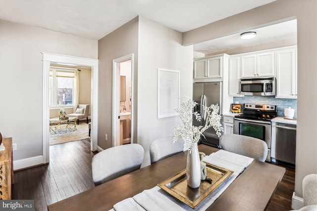 dining area with dark wood finished floors and baseboards