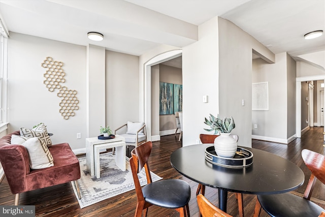 dining area with dark wood-type flooring and baseboards