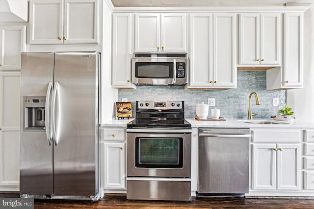 kitchen featuring stainless steel appliances, light countertops, a sink, and backsplash