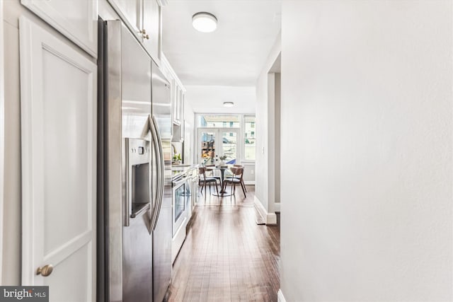 corridor featuring french doors, dark wood-style flooring, and baseboards