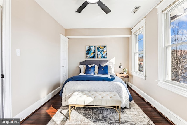 bedroom with visible vents, baseboards, ceiling fan, and dark wood-style flooring