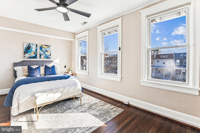 bedroom featuring a ceiling fan, dark wood-style flooring, visible vents, and baseboards