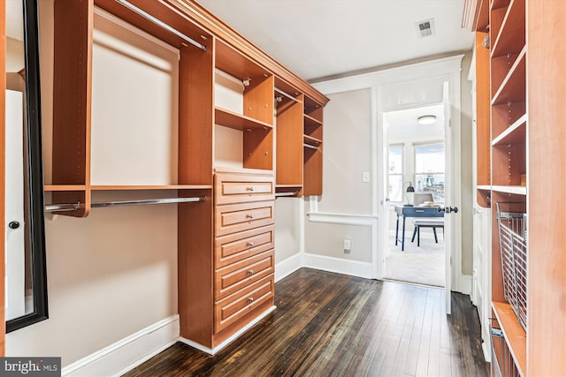 walk in closet with dark wood finished floors and visible vents