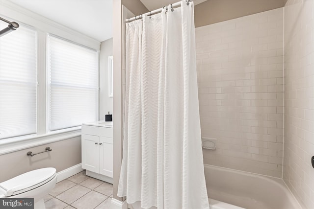 bathroom featuring baseboards, toilet, tile patterned floors, shower / bath combo with shower curtain, and vanity