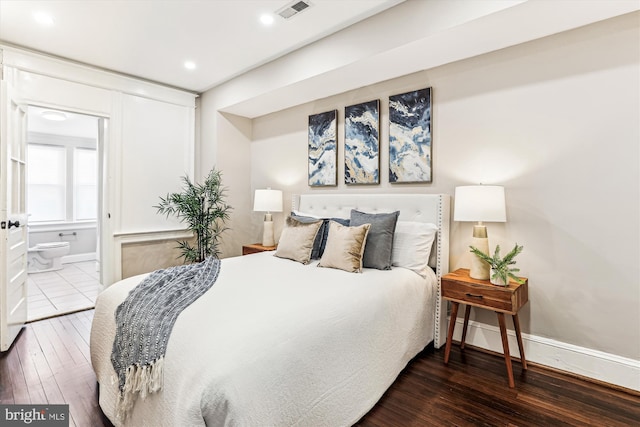 bedroom with hardwood / wood-style floors, ensuite bath, visible vents, and baseboards