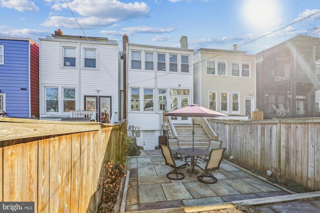 back of property featuring a patio and fence