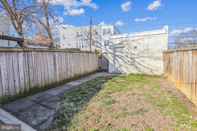 view of yard featuring a fenced backyard, a storage unit, and an outbuilding