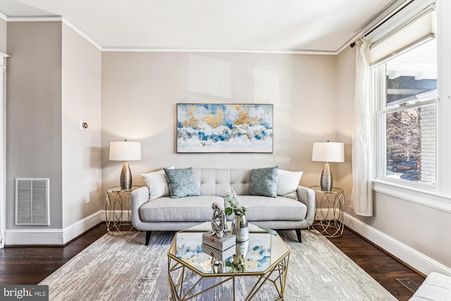 living room with baseboards, visible vents, crown molding, and wood finished floors