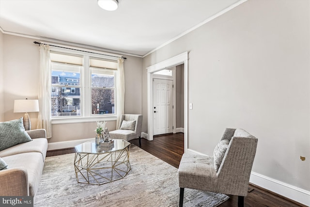 living room featuring crown molding, baseboards, and wood finished floors