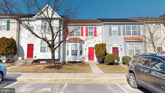 view of property with entry steps and uncovered parking