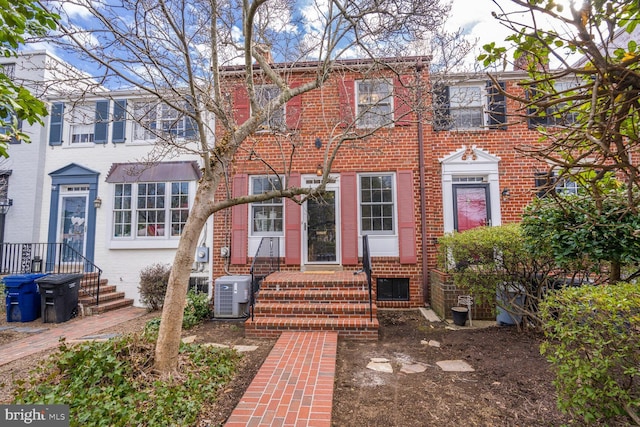 view of front of home featuring central AC and brick siding