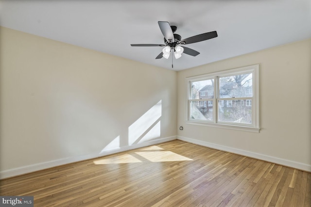 spare room featuring wood-type flooring, baseboards, and a ceiling fan