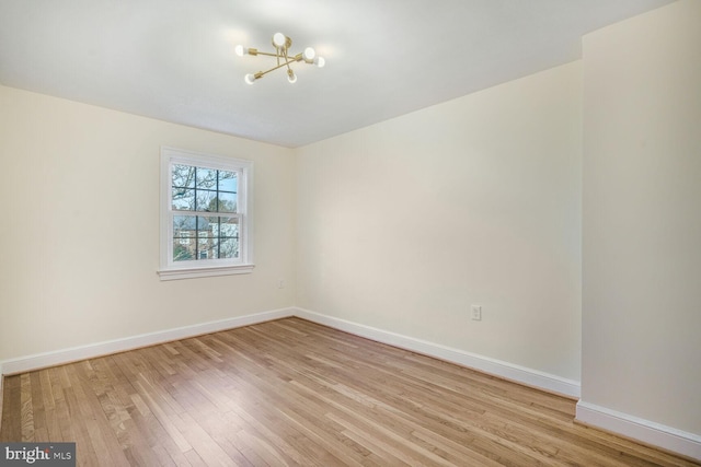 spare room featuring baseboards and light wood-style floors