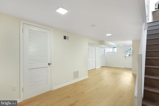 interior space featuring light wood-style flooring, stairway, and visible vents