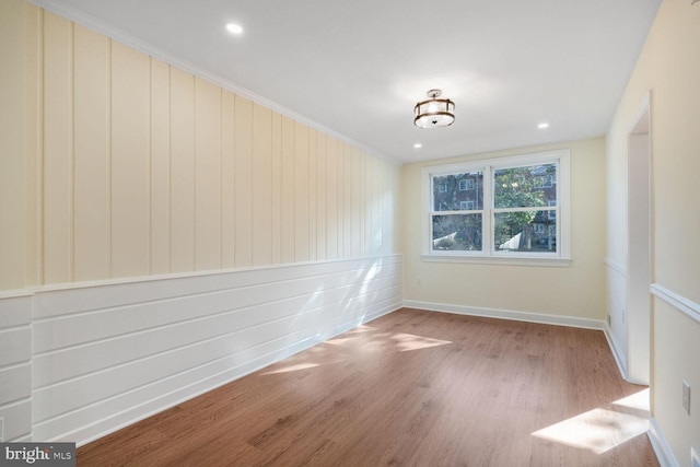 unfurnished room with baseboards, wood finished floors, and recessed lighting