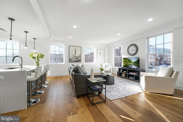 living area featuring light wood-style floors, baseboards, and recessed lighting